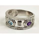 A 9CT WHITE GOLD MULTI-STONE BAND, with two amethyst faceted stones and a central topaz coloured