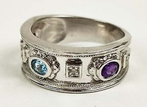 A 9CT WHITE GOLD MULTI-STONE BAND, with two amethyst faceted stones and a central topaz coloured