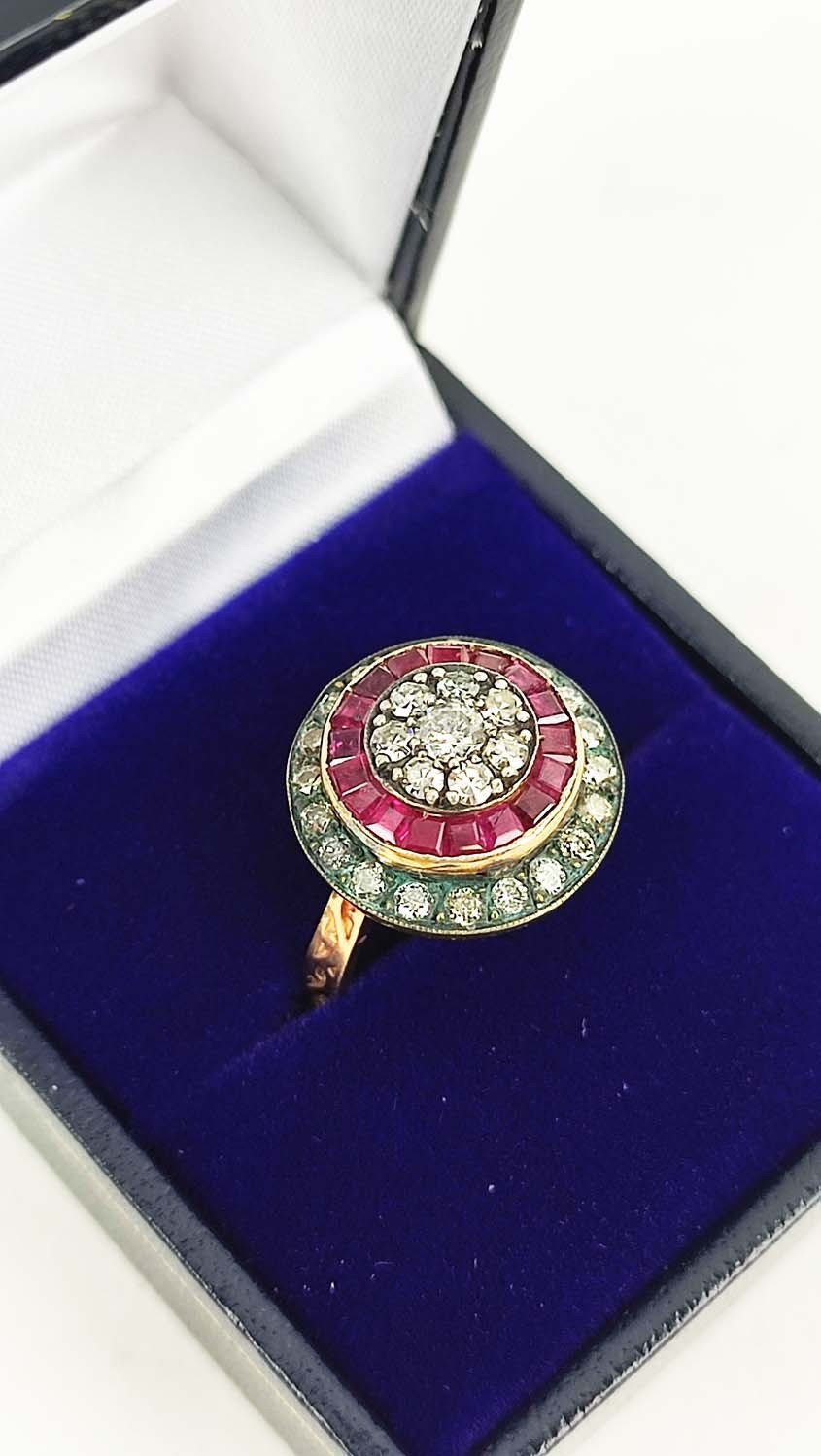 AN 8CT ROSE GOLD RUBY AND DIAMOND CLUSTER RING, with calibre cut rubies and round brilliant cut