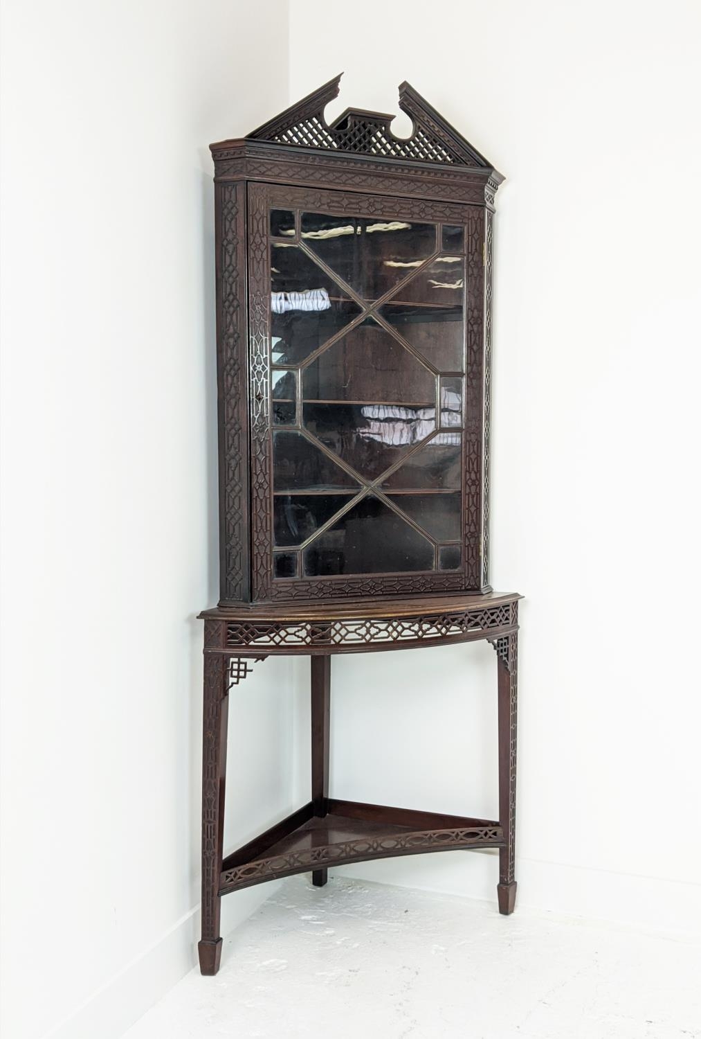 GLAZED CORNER CABINET ON STAND, Edwardian mahogany in Chippendale style with door and carved