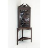 GLAZED CORNER CABINET ON STAND, Edwardian mahogany in Chippendale style with door and carved