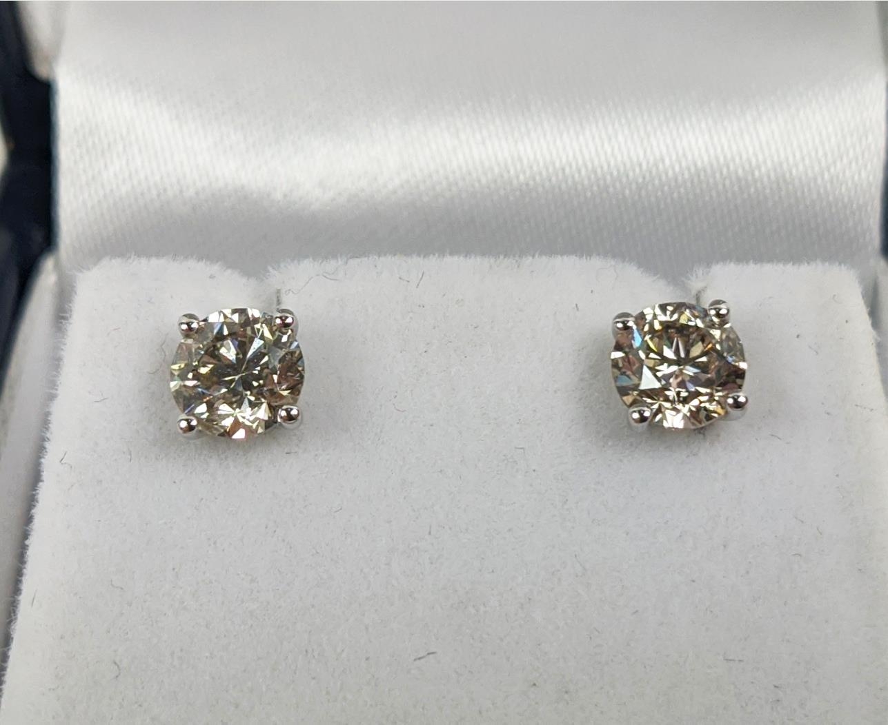 A PAIR OF 18CT WHITE GOLD DIAMOND SOLITAIRE STUD EARRINGS, each with a claw set round brilliant