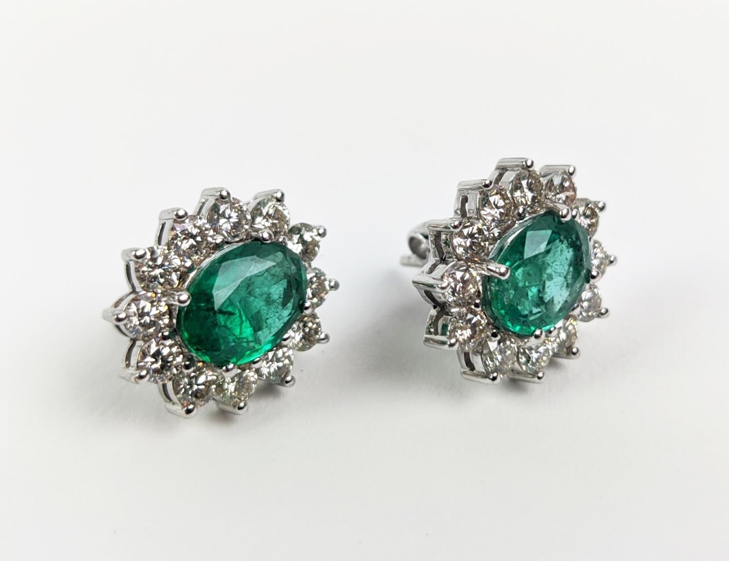 A PAIR OF 18CT WHITE GOLD EMERALD AND DIAMOND CLUSTER STUD EARRINGS, the oval mixed cut emerald - Image 4 of 8