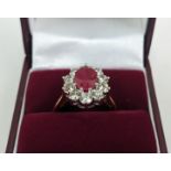 AN 18CT GOLD RUBY AND DIAMOND CLUSTER RING, the central mixed cut ruby of approximately 2.25 carats,