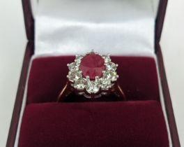 AN 18CT GOLD RUBY AND DIAMOND CLUSTER RING, the central mixed cut ruby of approximately 2.25 carats,