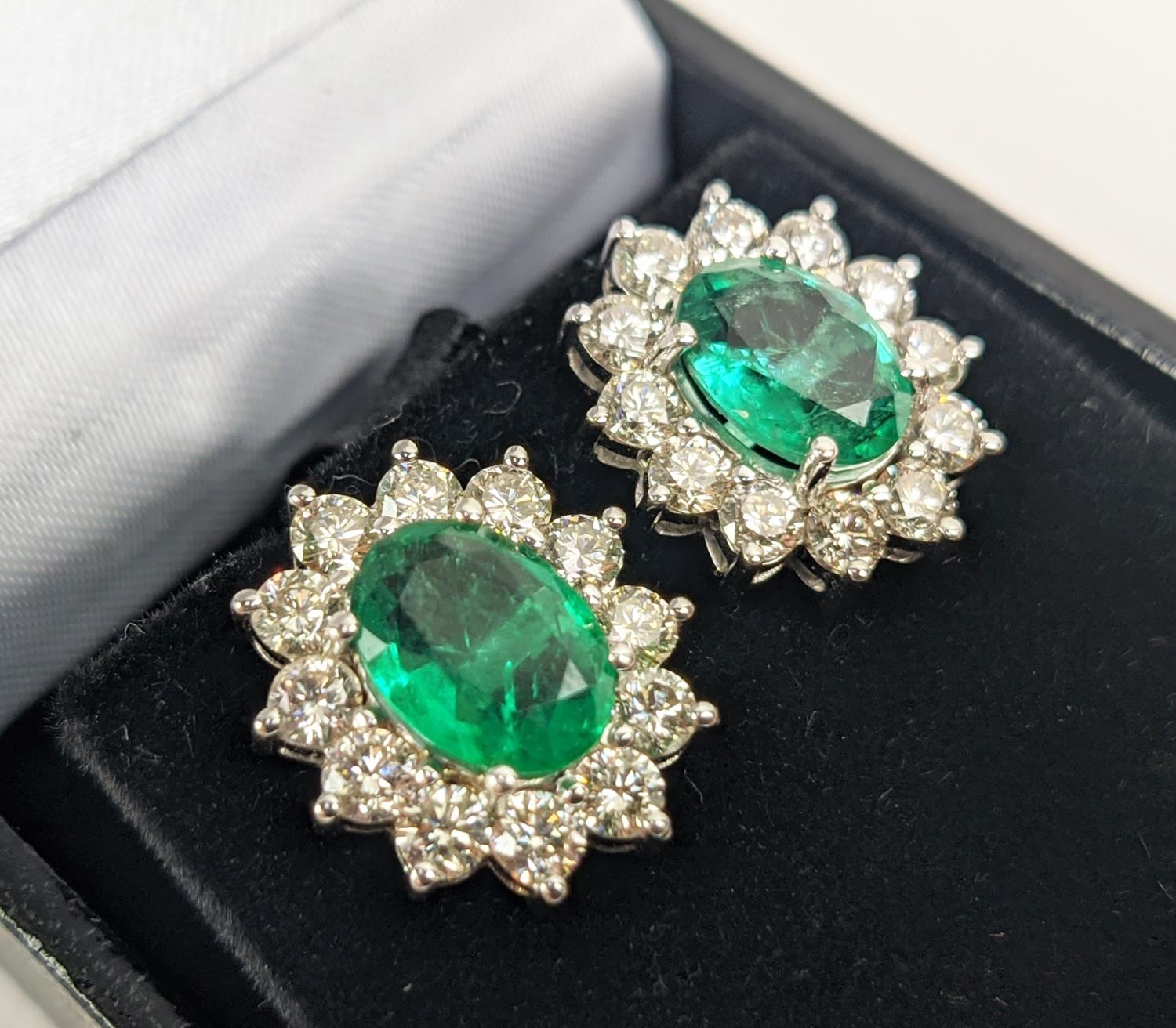A PAIR OF 18CT WHITE GOLD EMERALD AND DIAMOND CLUSTER STUD EARRINGS, the oval mixed cut emerald - Image 3 of 8