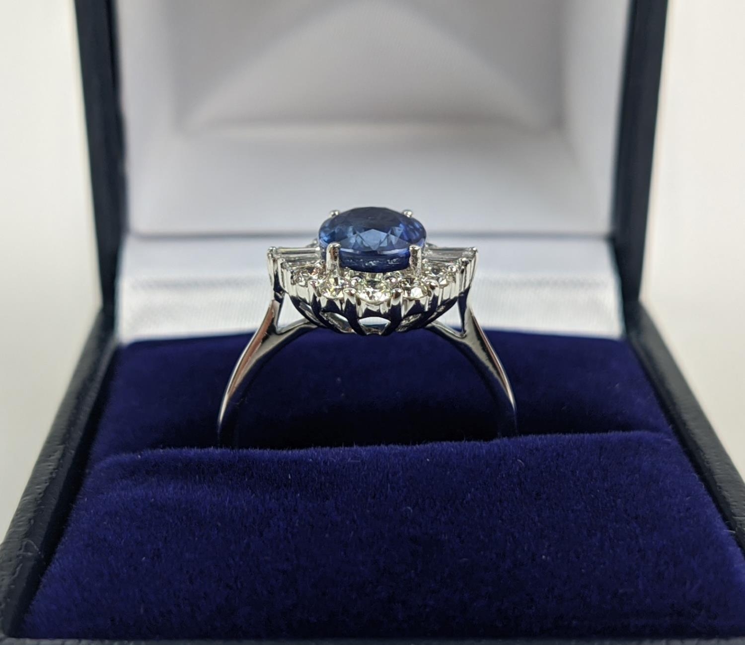 AN 18CT WHITE GOLD SAPPHIRE AND DIAMOND HALO RING, the central oval mixed cut sapphire of - Image 2 of 9