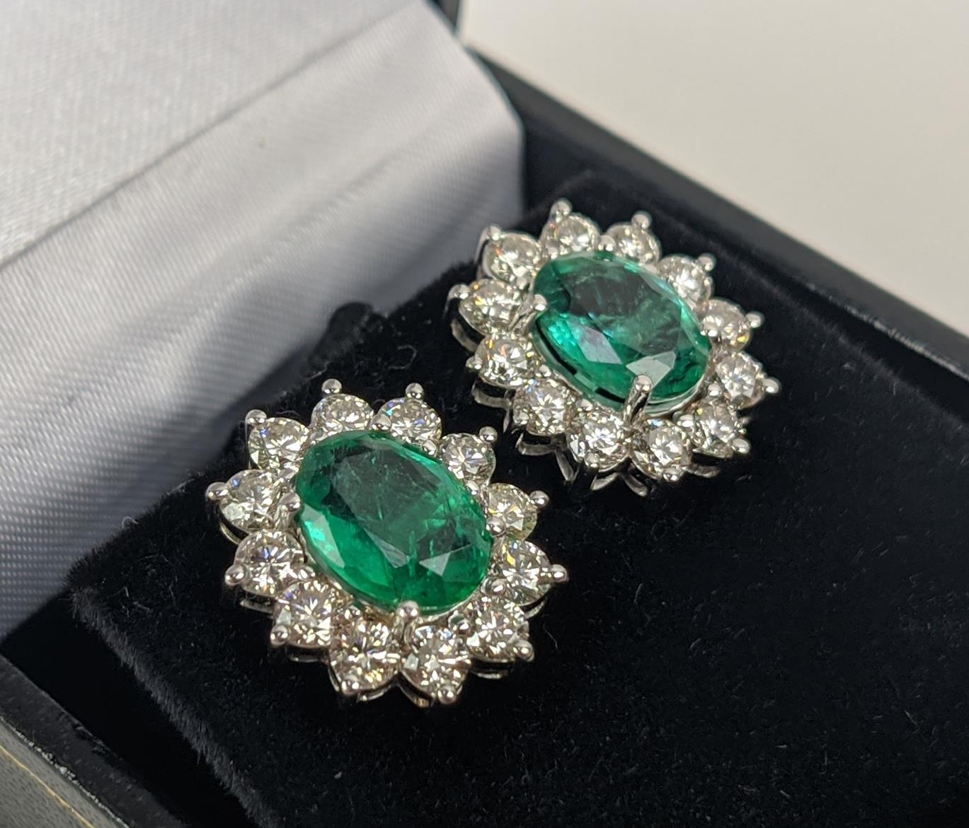 A PAIR OF 18CT WHITE GOLD EMERALD AND DIAMOND CLUSTER STUD EARRINGS, the oval mixed cut emerald - Image 2 of 8