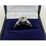 AN 18CT WHITE GOLD DIAMOND SOLITAIRE RING, with baguette cut diamonds to shoulders, the central