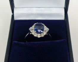 AN 18CT WHITE GOLD SAPPHIRE AND DIAMOND HALO RING, the central oval mixed cut sapphire of
