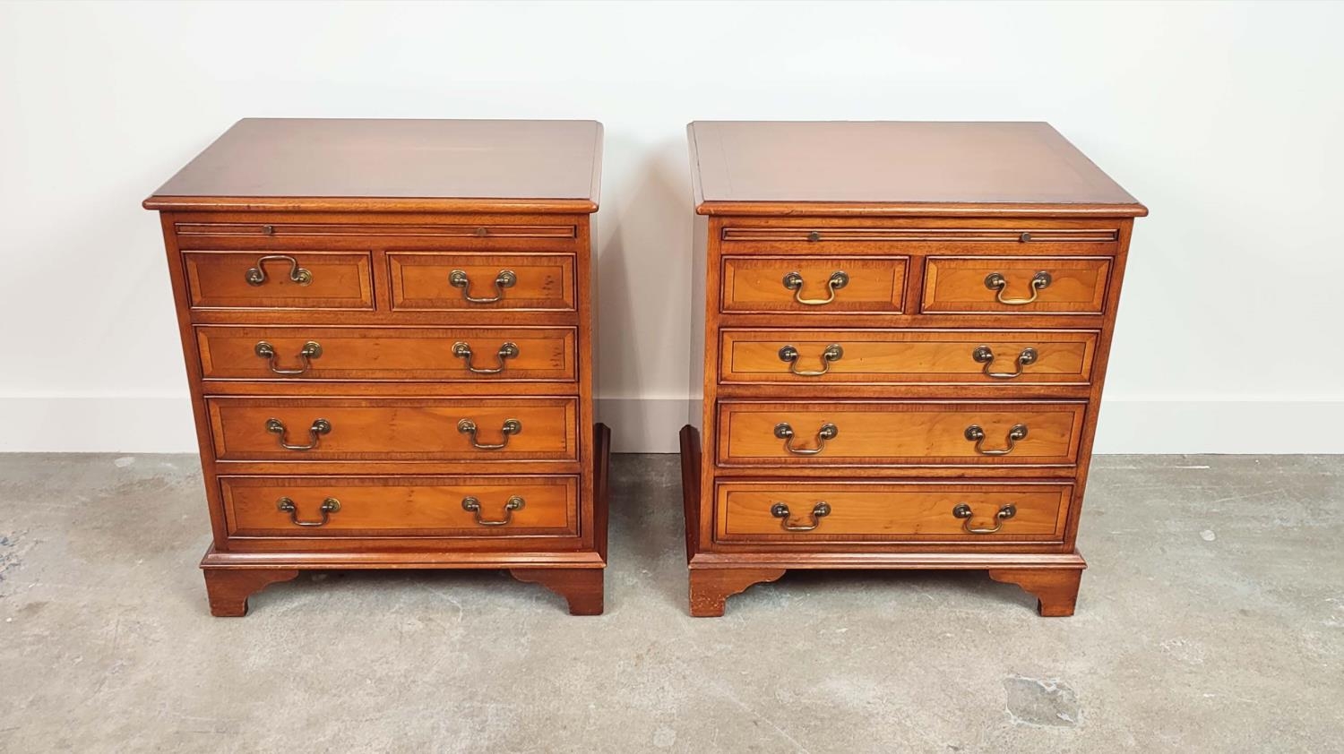 BEDSIDE CHESTS, a pair, Georgian style yewwood, each with green leather slide above five drawers,