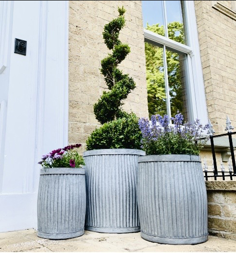 PLANTERS, a graduated set of three, in ribbed galvanised metal, largest 50cm H x 45cm x 45cm. (3)