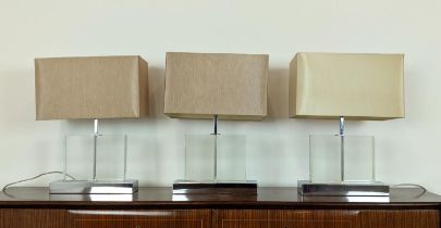 TABLE LAMPS, a set of three, glass on polished metal bases, each 52cm H overall including shades. (
