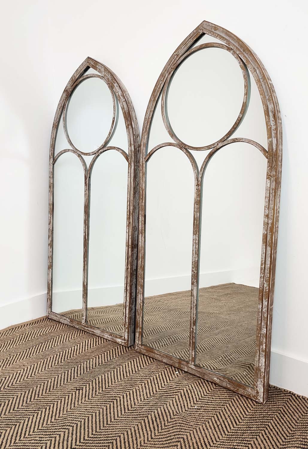 GARDEN MIRRORS, a pair, with arched metal frames, 123cm H x 56cm W. (2)