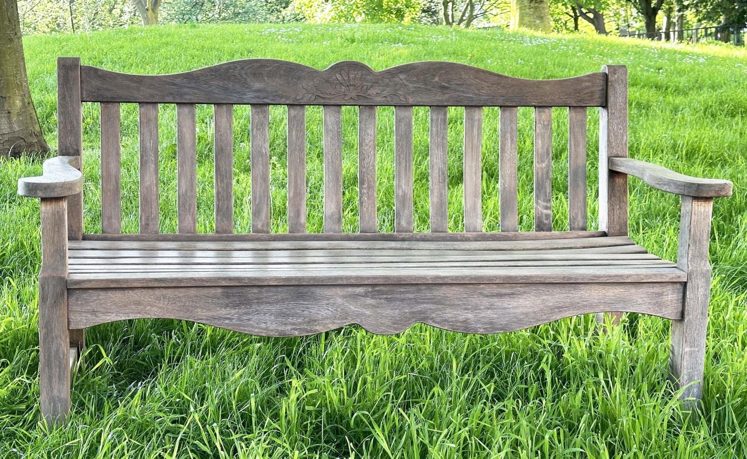 GARDEN BENCH BY 'BRIDGMAN AND CO', well weathered teak slatted with shaped yoke and shaped flat
