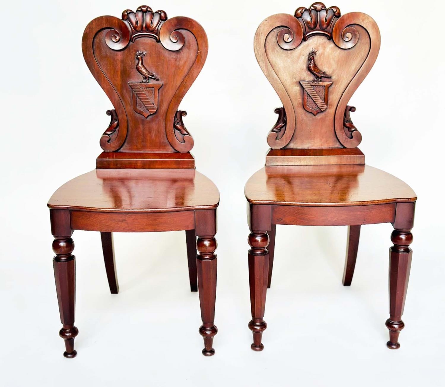 HALL CHAIRS, a pair, George III English Country House mahogany with carved armorial backs and