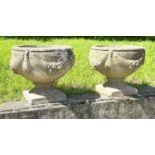 GARDEN URNS/PLANTERS, a pair, well weathered reconstituted stone of urn form with swag decoration,