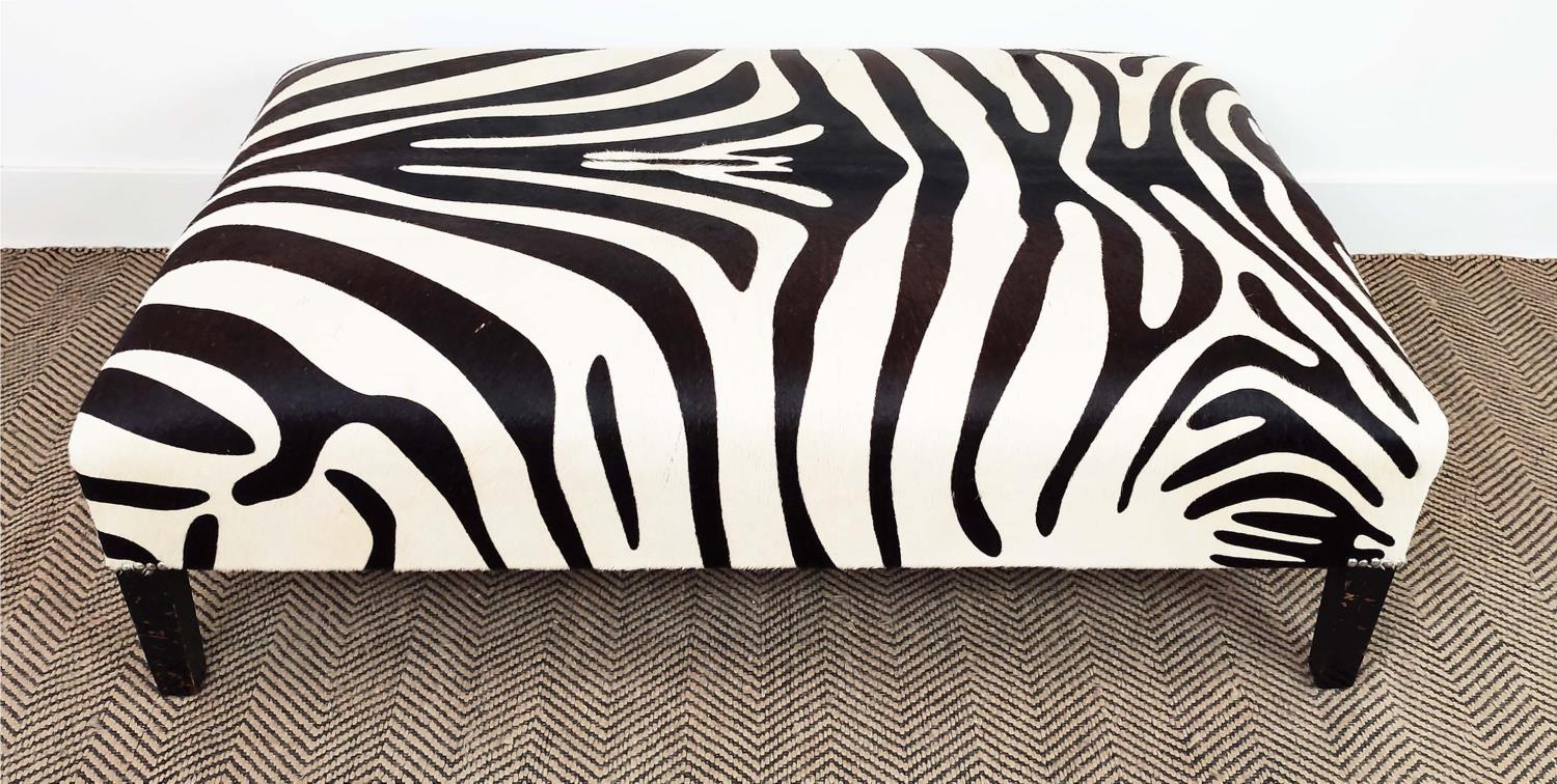 HEARTH STOOL, rectangular zebra skin on ebonised legs, 40cm H x 120cm x 76cm.