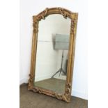 WALL MIRROR, early 19th century Continental giltwood and gesso with arched foliate scrolling frame