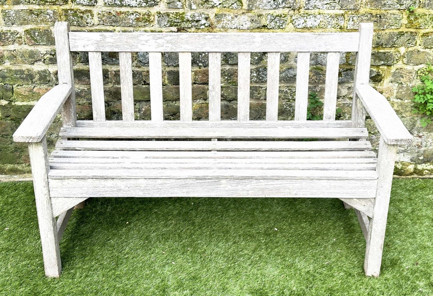 GARDEN BENCH, silvery weathered teak of slatted construction, 130cm W, by 'Lister'.