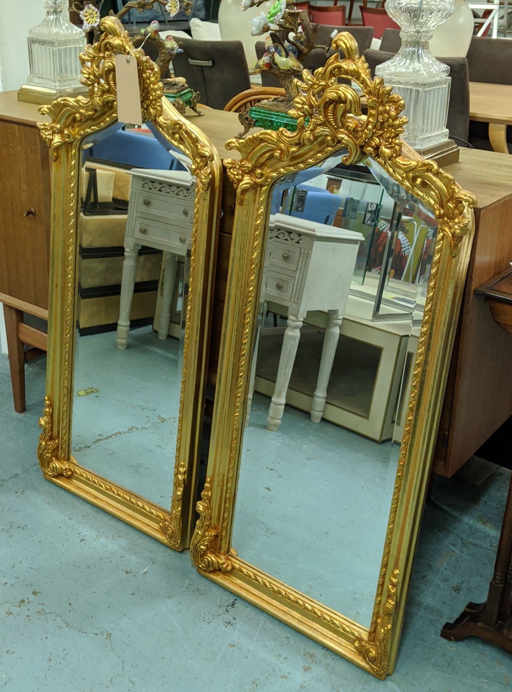 WALL MIRRORS, a pair, ornate gilt frames, 114cm H x 50cm. (2)