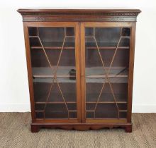 BOOKCASE, circa 1910, mahogany with a pair of glazed doors enclosing adjustable shelves, 142cm H x