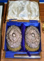 BOXED PAIR OF ORNATE SILVER BACKED BRUSHES