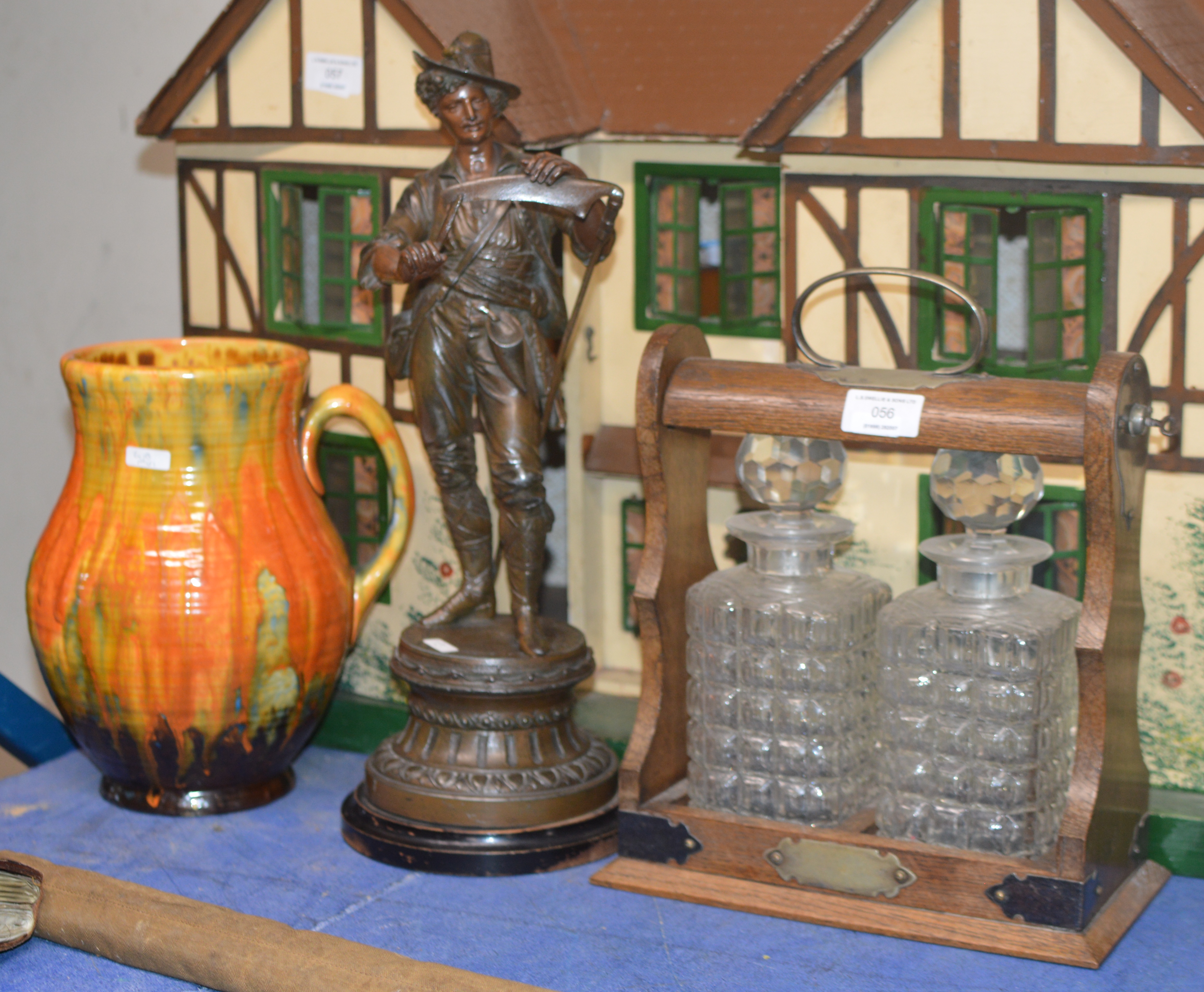 OAK 2 DIVISION TANTALUS WITH A PAIR OF DECANTERS, CROWN DUCAL POTTERY JUG AND A SPELTER FIGURINE