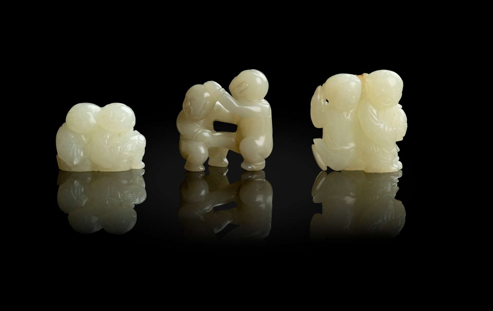 GROUP OF THREE JADE CARVINGS OF BOYS AT PLAY