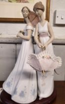 Lladro group of two young ladies with parasols, 37cm, with oval wood stand.