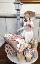 Lladro flower seller figure of young lady with parasol, barrow and baskets of flowers and lamp post,