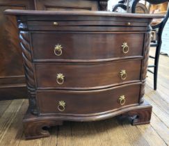 A 20th century mahogany serpentine style chest of drawers, having three drawers, with brass handles.