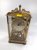 A brass mantel /lantern clock, glass panelled, with rotating ball pendulum, the silvered dial with