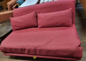 A sofa bed, upholstered in red fabric, with two cushions. 80cm x 160cm x 106cm.