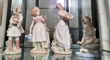 Four Lladro figures of girls- one with bird, two with flowers, and one with butterfly and watering