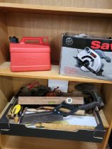 A collection of various vintage tools, and a power saw.