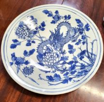 An Oriental porcelain blue and white dragon dish, depicting a four-clawed dragon amidst foliate