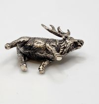 A novelty silver model of a stag, with textured body, marked 'sterling' to leg, 3.7 cm long, 2.8