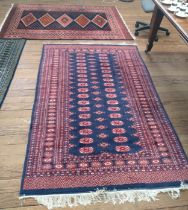 Two red and blue Pakistan Bokhara rugs. (2)