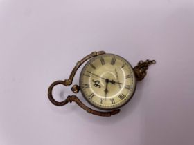 A brass mounted desk ball clock, with hinged handle, Roman numeral dial, and brass tassel, clock