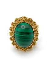 A yellow gold and malachite ring, set with an oval cabochon malachite, measuring approximately 16