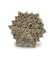 An 18ct white gold and diamond hexagonal cluster cocktail ring, the raised cluster set with thirty