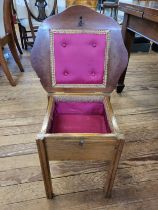 A plain wooden sewing table of square form, with hinged lid, and padded satin interior, supported on