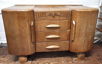 An Art Deco wooden sideboard with carved decoration, shelved interior, rounded doors and three