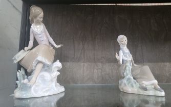 Lladro seated with a fish, 23cm, and girl seated with a dove, 18cm.