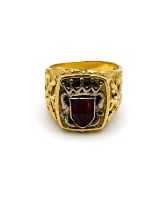 An unusual yellow gold gents ring, set with a shield-cut faceted red paste gemstone, within a shield