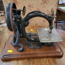 A vintage sewing machine, on wooden base.