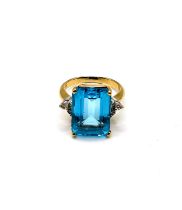 An 18ct yellow gold, diamond, and blue topaz ring, set with three stones to each shoulder (four