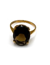 A 9ct yellow gold and smoky quartz ring, set with an oval stone measuring approximately 16 x 12