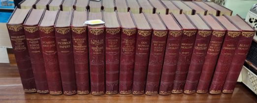 A set of sixteen Dickens novels with red leather bindings.